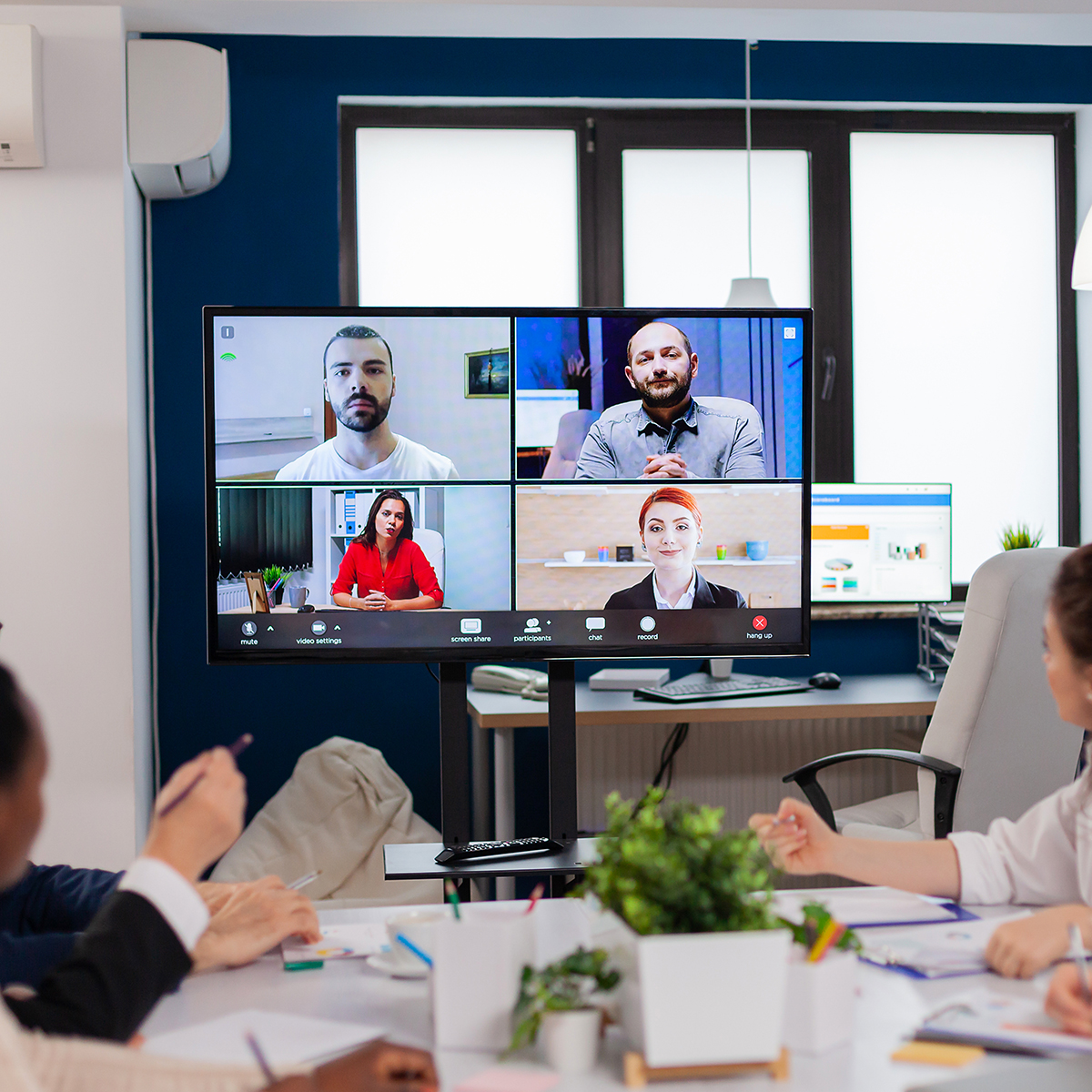 Video conferencing setup with multiple participants displayed on a monitor, illustrating seamless collaboration for telehealth and remote meetings in a modern workspace.